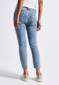Lichtblauwe spijkerbroek met een hoge taille, vijf zakken en een slim fit, met een vervaagde was en omgeslagen enkels.