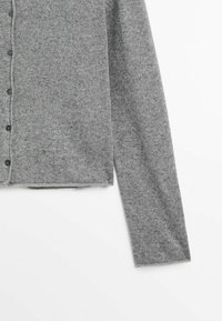 Cardigan gris en maille à manches longues avec des boutons noirs, présenté de la moitié du torse jusqu'à la manche droite sur fond blanc.