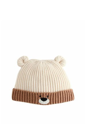 Cappello lavorato a maglia in crema chiaro e marrone con texture a costine. Presenta un design con volto di orso e orecchie sulla parte superiore, oltre a una visiera marrone a contrasto.