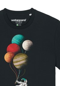 Zwarte t-shirt met een illustratie van een astronaut die kleurrijke planetenballonnen vasthoudt in rode, oranje, teal, crème en bruine tinten.