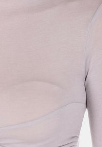 Top aderente rosa chiaro con una texture liscia, caratterizzato da un dettaglio di cucitura curva e una leggera arricciatura sul lato. Maniche lunghe.