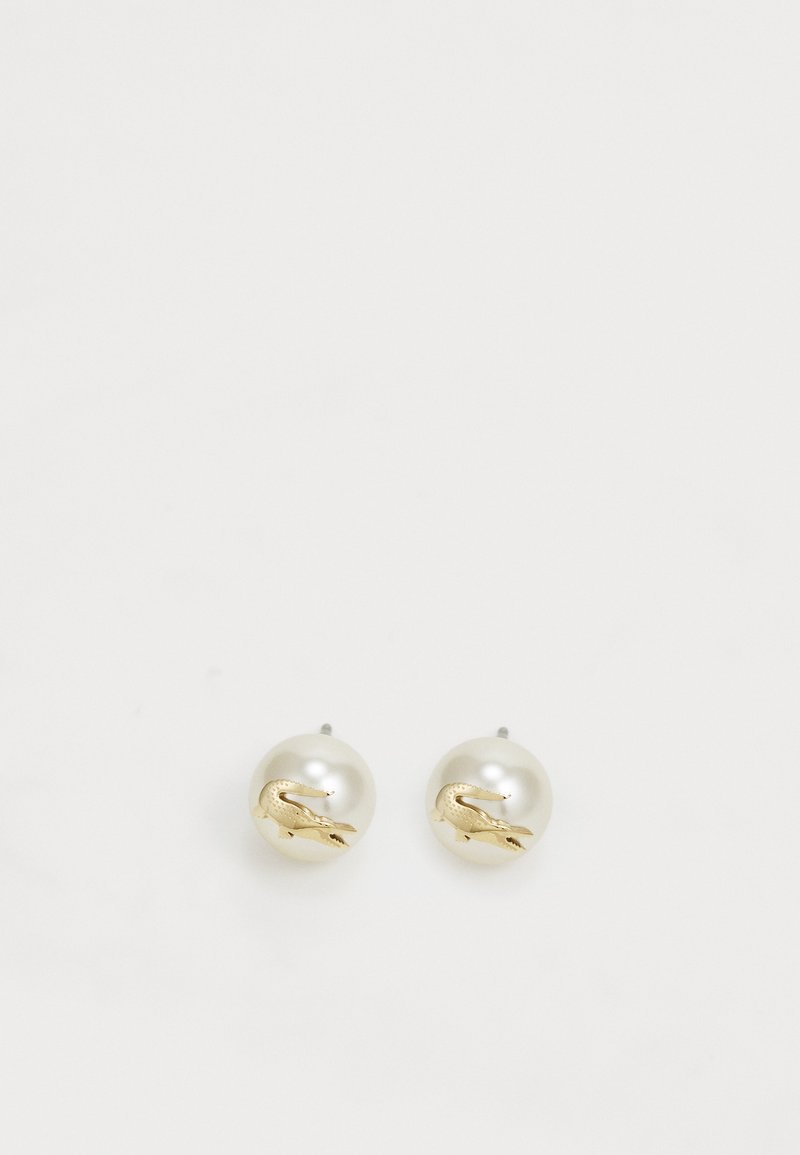 Brincos de pérola com acabamento brilhante; adornados com um pequeno detalhe em forma de crocodilo dourado em cada brinco. Forma circular, textura suave.