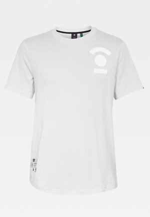 Bílá bavlněná tričko s krátkými rukávy, kulatým výstřihem, s potiskem kruhového designu a vodorovným pruhem v bílém na přední straně a s důvody značky po straně.