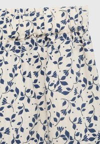 Lagana suknja od tkanine sa naboranim pojasom, koja ima mornarsko plavi cvjetni uzorak na krem pozadini. Tekstura se čini mekanom i laganom.