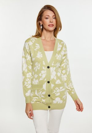 Cardigan cu nasturi, de culoare verde pal, cu un model floral alb, având mâneci lungi, două buzunare frontale și manșete și un tiv cu model canelat.