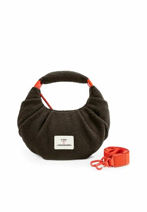 Bolso texturizado marrón oscuro con asa corta y etiqueta blanca en la parte delantera, combinado con una correa naranja brillante desmontable con cierres metálicos.