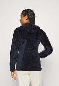 Navy hoodie featuring a mix of soft, textured fabric and smooth material, with a kangaroo pocket and a hood. Back view shows design contrast.
