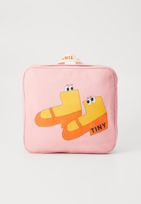 Rosa veske med gule og oransje tegneseriestøvler med øyne. "TINY"-tekst i svart på designet. Tekstilmateriale med en glatt overflate.