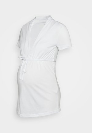 Top de maternidade branco feito de algodão macio. Apresenta mangas curtas, um decote em V profundo e um laço na cintura para um ajuste ajustável.