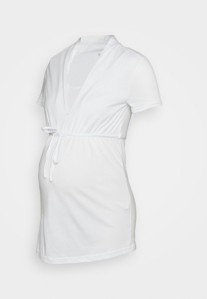 Top de maternidade branco feito de algodão macio. Apresenta mangas curtas, um decote em V profundo e um laço na cintura para um ajuste ajustável.