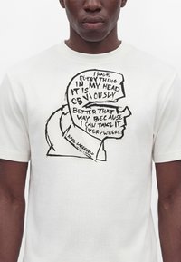 Άνδρας που φοράει λευκό T-shirt με μαύρη γραμμή σχεδίου προφίλ κεφαλιού που περιέχει το κείμενο "I have everything in my head it is obviously better that way because I can take it everywhere."