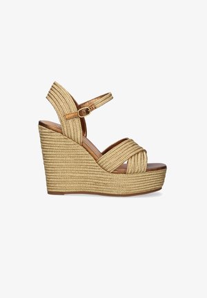 Sandalia beige de cuña tejida con tira en el tobillo y hebilla, con tiras cruzadas sobre los dedos y tacón alto con plataforma.