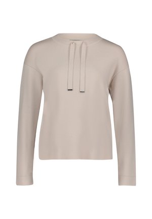 Jasno beżowa bluzka z długim rękawem i okrągłym dekoltem. Posiada sznurek ze metalowymi końcówkami, prążkowaną strukturę oraz luźny krój.