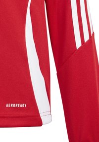 Rode sportieve shirt met witte accenten aan de zijkanten, gestructureerde stof en "AEROREADY" logo. Lange mouwen en een ademend ontwerp.