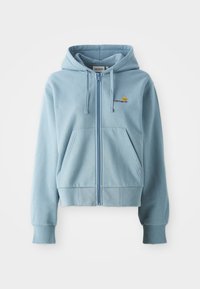 Sudadera con cremallera de color azul claro, hecha de tela suave, con capucha ajustable, bolsillos tipo canguro y logotipo bordado en el pecho.