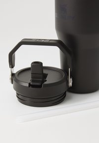 Black stainless steel travel mug with a secure lid featuring a spout and handle. Includes a clear plastic straw next to the mug.