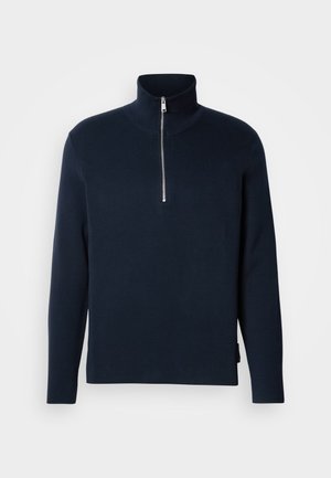 Granatowy sweter dzianinowy z wysokim kołnierzem i zapięciem na pół-zamek. Posiada długie rękawy oraz gładką, miękką strukturę.