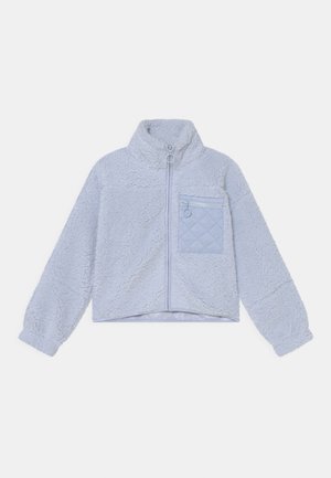 Chaqueta de forro polar gris claro con cremallera completa, cuello alto, mangas largas y un bolsillo con cremallera acolchado en el pecho, en el lado izquierdo.