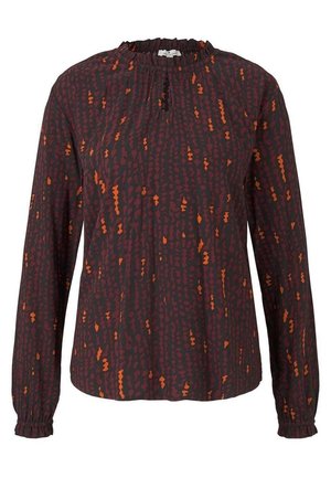 Blouse à manches longues violet foncé avec des taches abstraites orange, col et poignets à volants, et une petite ouverture en forme de trou de serrure à l’avant.