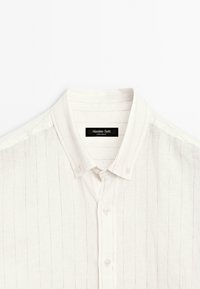 Weißes Hemd mit dünnen vertikalen Streifen und einem geknöpften Kragen, mit einem "Massimo Dutti"-Etikett im Nacken.