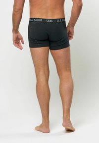 Schwarze Baumwoll-Boxershorts mit einem U.S. Polo Assn. Logo-Bund, enganliegendem Design und glatter Textur, von hinten betrachtet.