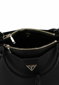 Borsa nera con una texture liscia, dotata di accessori in oro e un logo triangolare. L'apertura con zip rivela un interno spazioso.