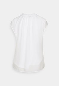 Top bianco a maniche corte realizzato in tessuto leggero. Presenta un collo arricciato e fessure laterali all'orlo per facilitare il movimento.