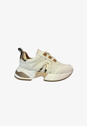 Sneakers bianchi con accenti dorati e suola beige. Presentano una finitura in pelle liscia, un logo prominente e un design robusto. Inclusa una linguetta per il rimorchio.