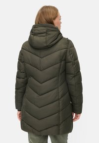 Olijf groene pufferjas met een chevronpatroon, voorzien van een capuchon, lange mouwen en stikdetails. Zachte textuur en warme isolatie.