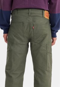 Gröna canvas cargo-byxor med rak passform, som har flera fickor och en strukturerad midja. Levi's logotyppatch på baksidan.