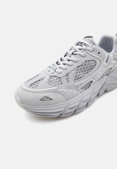 Baskets gris clair avec des panneaux en mesh et en daim, semelle épaisse texturée, lacets blancs, et marquage "ICEBERG 1974" sur le côté et la languette.