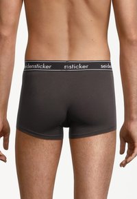 Dunkelgraue Boxerbriefs mit glatter Textur, ausgestattet mit einem schwarzen Bund mit weißem "seidensticker"-Logo. Kurzbein-Design.