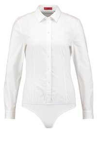 Blouse blanche à manches longues, boutonnée, avec col, taille cintrée et bas body intégré.
