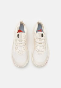 Baskets de sport blanches avec une tige en mesh, des accents gris clair et un logo rouge sur la semelle intérieure. Présentent un col rembourré et des lacets plats.