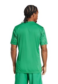 Grünes sportliches Trikot mit kurzen Ärmeln und strukturierten Akzenten an den Schultern. Hergestellt aus leichtem Stoff, mit einem Rundhalsdesign.