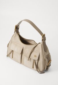 Μπεζ σουέτ τσάντα με κύρια θήκη με φερμουάρ, δύο μπροστινές τσέπες, χρυσές λεπτομέρειες και κοντό, ρυθμιζόμενο λουρί.