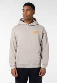 Light gray hoodie with a kangaroo pocket, featuring orange text "AUTHENTIC COLLECTIVE" on the left chest. Soft cotton fabric.