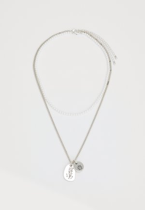 Collar en capas que presenta una cadena de plata y una hilera de perlas blancas, adornado con un colgante de rayo y un charm de sol.