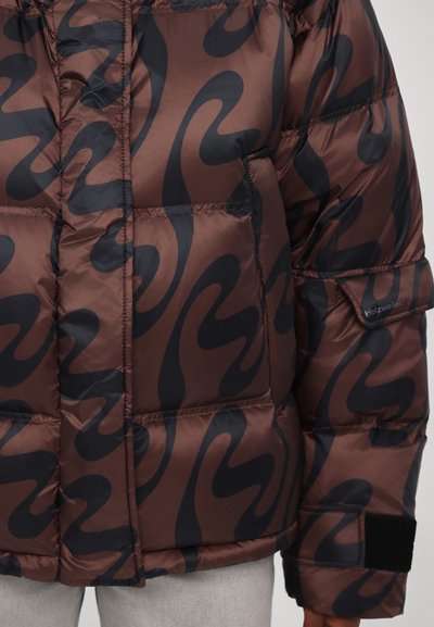 Brown puffer jacket with a large black wavy pattern, featuring quilted sections and a side logo tag. Smooth, shiny texture.