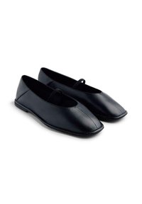 Ballet flats en cuir noir avec un bout arrondi, présentant une fine lanière sur l'arche et une texture lisse et homogène. Semelle à profil bas.