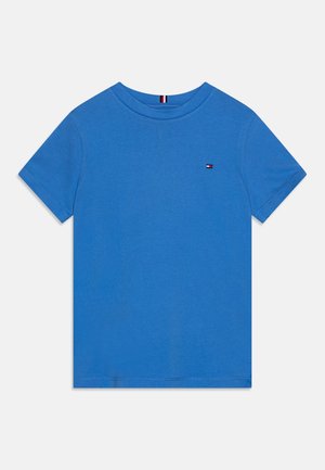 Blaues Baumwoll-T-Shirt mit Rundhalsausschnitt, kurzen Ärmeln und einem kleinen Logo-Patch auf der linken Brust. Glatte Textur, klassischer Schnitt.