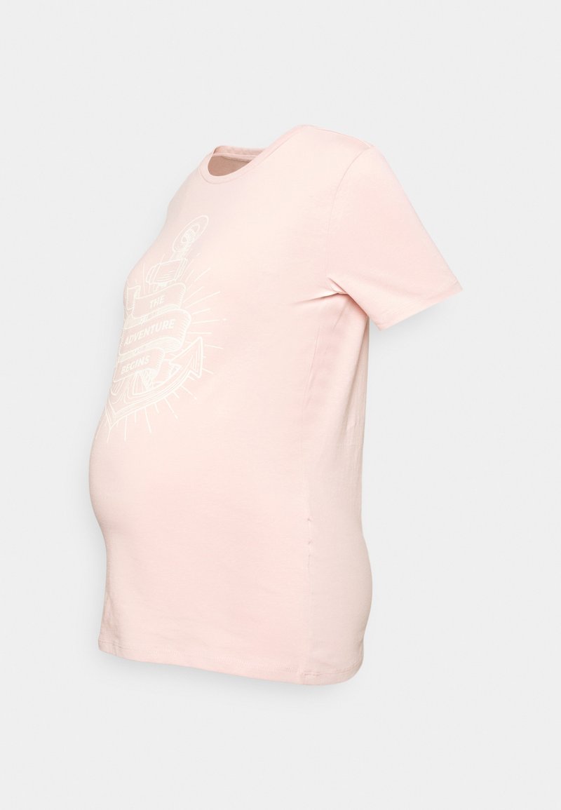 T-shirt de maternidade rosa claro, mangas curtas, gola redonda, com um design gráfico branco estampado com o texto "A AVENTURA COMEÇA." Textura suave.