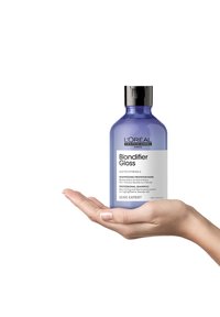 Champú Blondifier Gloss de L'Oréal Professionnel en una botella redondeada, clara y púrpura con tapa negra. Tamaño manejable de 300 ml.