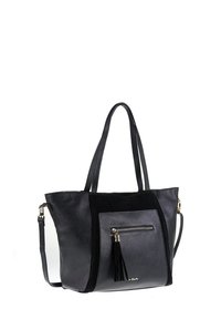 Zwarte leren tote bag met dubbele handvatten, voorzak met rits en franjes, en een afneembare schouderriem, angled view op witte achtergrond.