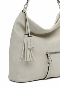 Hellgraue Hobo-Tasche aus weichem Leder mit einem Quastenakzent und einem silbernen Reißverschlussdetail. Verfügt über einen stabilen Schultergurt und ein abnehmbares Etikett.
