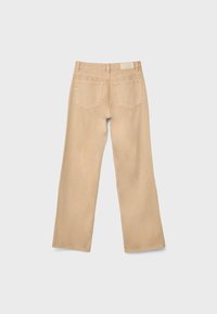 Bež traperice s ravnim krojem, pet džepova i oznakom na stražnjem pojasu.