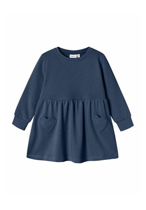 Robe bleu marine à manches longues pour tout-petit avec encolure ronde et deux poches en forme de cœur sur la jupe froncée.