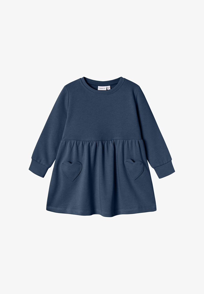 Robe bleu marine à manches longues pour tout-petit avec encolure ronde et deux poches en forme de cœur sur la jupe froncée.