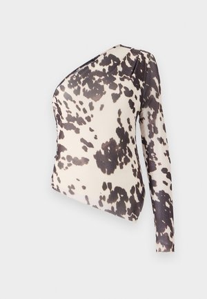 Top de un solo hombro en tela ligera con un fondo beige y manchas irregulares negras, textura suave y diseño ajustado.