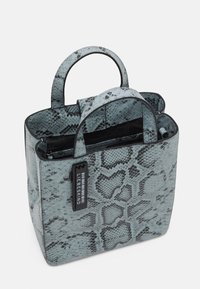 Liten handväska i ormskinnsstil med ljusblå utsida och svarta detaljer. Utrustad med två övre handtag och dragkedjestängning.